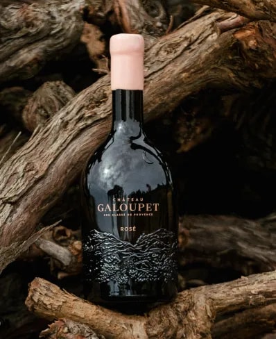 Château Galoupet Cru Classé Côtes de Provence bottle on cut vine woods in organic vineyards.